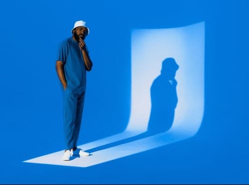 A man casts a shadow on a blue background.